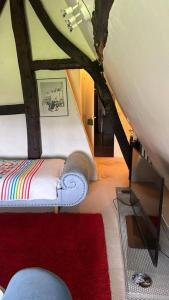 - un salon avec un canapé et un tapis rouge dans l'établissement Chaumière de charme cosy, à Saint-Éloi-de-Fourques