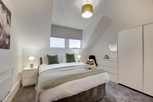 um quarto com uma cama grande e almofadas verdes em Hudson's Haven Apartments by Week2Week em Newcastle upon Tyne