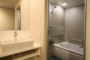 a bathroom with a sink and a tub and a shower at Hotel Gracery Shinjuku in Tokyo