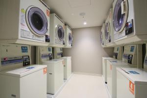 a laundry room with multiple washing machines and cabinets at Hotel Gracery Shinjuku in Tokyo