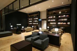 東京的住宿－格拉斯麗新宿酒店，客厅配有椅子、桌子和书架