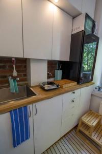 uma pequena cozinha com armários brancos e um lavatório em A Lovely apartment near Railway station and Arena. em Tampere