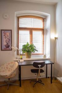 a office with a desk and a chair and a window at A Lovely apartment near Railway station and Arena. in Tampere