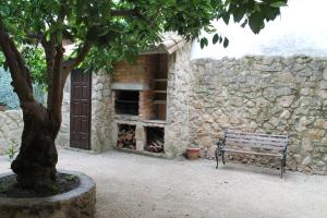 ławka obok kamiennej ściany z kominkiem w obiekcie EL CORRAL DE LA VERA w mieście Losar de la Vera