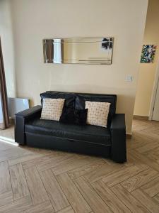 a black leather couch in a living room at Le Sancy appartement in Beausoleil