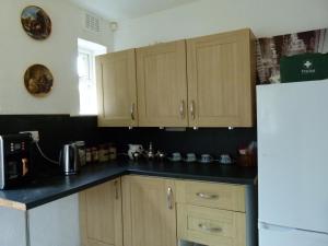 a kitchen with wooden cabinets and a white refrigerator at Conner house in Middlesbrough