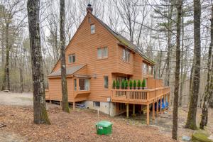 a large wooden house with a deck in the woods at North Conway Townhome with Private Hot Tub and Deck! in North Conway