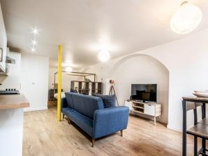 a living room with a blue chair and a tv at Pass the Keys Stylish and central character flat with courtyard in Exeter