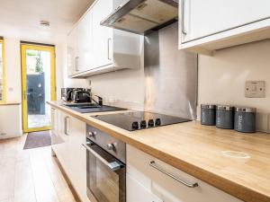a kitchen with white cabinets and a stove top oven at Pass the Keys Stylish and central character flat with courtyard in Exeter