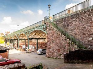 a large brick wall with a staircase next to a building at Pass the Keys Stylish and central character flat with courtyard in Exeter