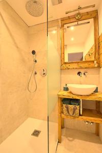 La salle de bains est pourvue d'un lavabo et d'une douche. dans l'établissement Alpen Apartment Werfenweng - Ruhe - Pool, à Werfenweng