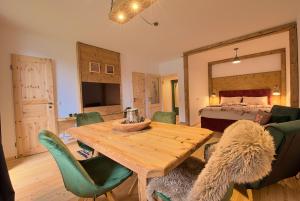 een woonkamer met een houten tafel en een bed bij Alpen Apartment Werfenweng - Ruhe - Pool in Werfenweng