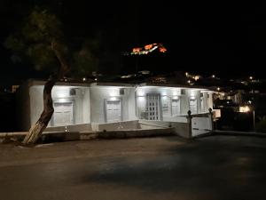 un edificio blanco con una cometa en el aire por la noche en Spanos Apartments - Panteli, en Panteli