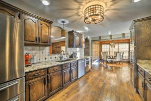 a large kitchen with wooden cabinets and a table at Peaceful Big Sandy Home with Deck on Kentucky Lake! in Big Sandy