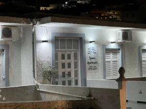 Spanos Apartments - Panteli في Panteli: مبنى أبيض بباب أبيض ونوافذ