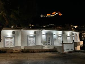 Un bâtiment blanc avec des lumières allumées la nuit dans l'établissement Spanos Apartments - Panteli, à Panteli