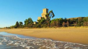 a view of a beach with a building in the background at Lo Spillo in Pineto