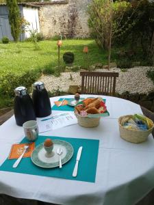 a table with plates of food and a bowl of bread at L'ancien prieuré in Lorrez-le-Bocage