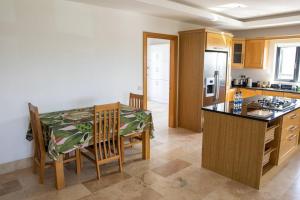 a kitchen with a table and a dining room at Osher in Milehouse