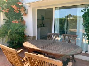 a wooden table and chairs on a patio at Studios Coll, Terrace & Pool in Sant Martí d'Empúries