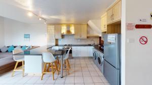 eine Küche mit einem Kühlschrank sowie einem Tisch und Stühlen in der Unterkunft San Lameer Villa 1916 by Top Destinations Rentals in Southbroom