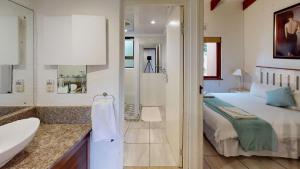 ein Schlafzimmer mit einem Bett und ein Badezimmer mit einem Waschbecken in der Unterkunft San Lameer Villa 1916 by Top Destinations Rentals in Southbroom