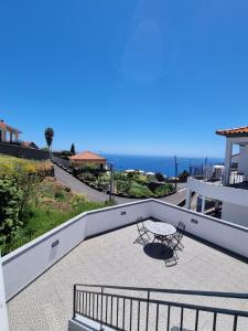 a balcony with a table and a view of the ocean at Casa agapanthe in Estreito da Calheta