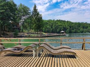 two benches sitting on a wooden pier next to a lake at Guest House Vilnius in Vilnius