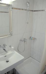 a white bathroom with a shower and a sink at Hotel Weisses Kreuz in Interlaken