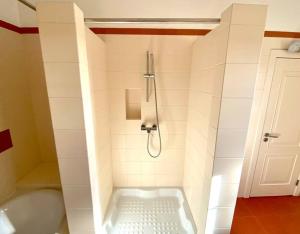 a bathroom with a bath tub with a shower at Oceans house - Pool, Sauna, 22 Sleeps, 7m to beach in Carcavelos