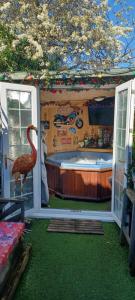 uma casa de banho com banheira e um flamingo num quarto em Chalet with hot tub room em Clanfield