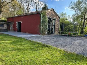Um edifício de tijolos vermelhos com uma bola de futebol à frente. em Guest House and swimming pool em Romsée