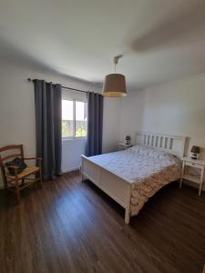 a bedroom with a large bed and a window at Casa agapanthe in Estreito da Calheta