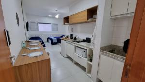 eine Küche mit einer langen Theke in einem Zimmer in der Unterkunft Morada da Fé II à 300 m da canção nova Cond. da Fé in Cachoeira Paulista + 16 Fotos