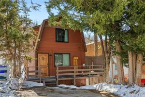 une maison brune avec une véranda et des arbres dans l'établissement Le Chalet of Arrowbear Lake, à Running Springs