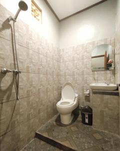 a bathroom with a toilet and a sink at Geriya House in Ubud