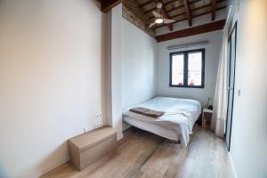 a small bedroom with a bed and a window at Maritime House Valencia Beach in Valencia