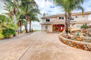 a house with palm trees in front of a driveway at Mountaintop Ramona Home Private Pool, Near Lake! in Ramona