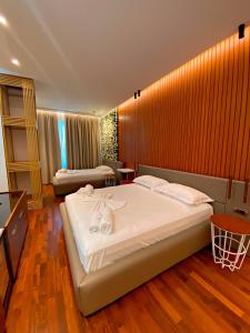 una camera da letto con un grande letto con asciugamani di Peaky Hotel a Durrës