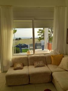 a living room with a couch and a large window at By the sea dome in Maronia