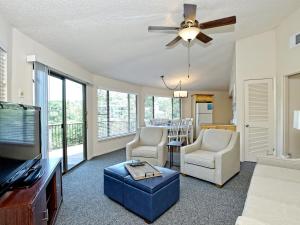 a living room with a flat screen tv and two chairs at Lakefront Bungalow With Pool & Hot Tub #4 in Lakeway