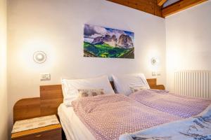 1 dormitorio con 1 cama y una pintura en la pared en Aparthotel Alperose Strembo, en Strembo