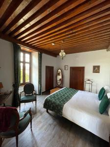 a bedroom with a large bed and a wooden ceiling at Manoir du Grail in Devesset