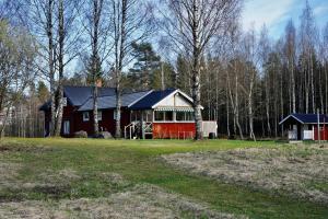 a red house in the middle of a field at Holiday Home Bengtsfors in Bengtsfors