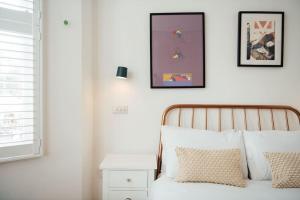 Stylish 2 Bedroom Flat with a Private Sauna في فينتشلي: غرفة نوم بسرير وصورتين على الحائط