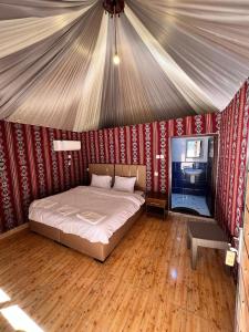 - une chambre avec un lit dans une tente dans l'établissement Feras Camp Wadi Rum, à Wadi Rum