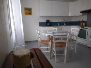 a kitchen with a table and chairs and a drink at T2 avec terrasse ensoleillée à 5 min de la plage Pornichet in Pornichet