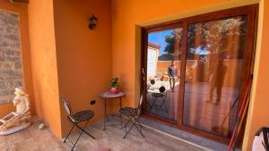 a porch with chairs and a door to a patio at Fadda Holiday House - Managed By Antonio Sanna in Austis