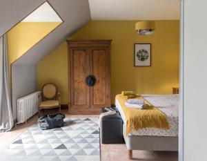 a bedroom with a bed and a yellow wall at Les Aulnaies - B&B in Mareuil-sur-Cher