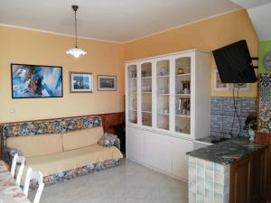 sala de estar con sofá y TV en Appartamento Policastro - Vista mare, 